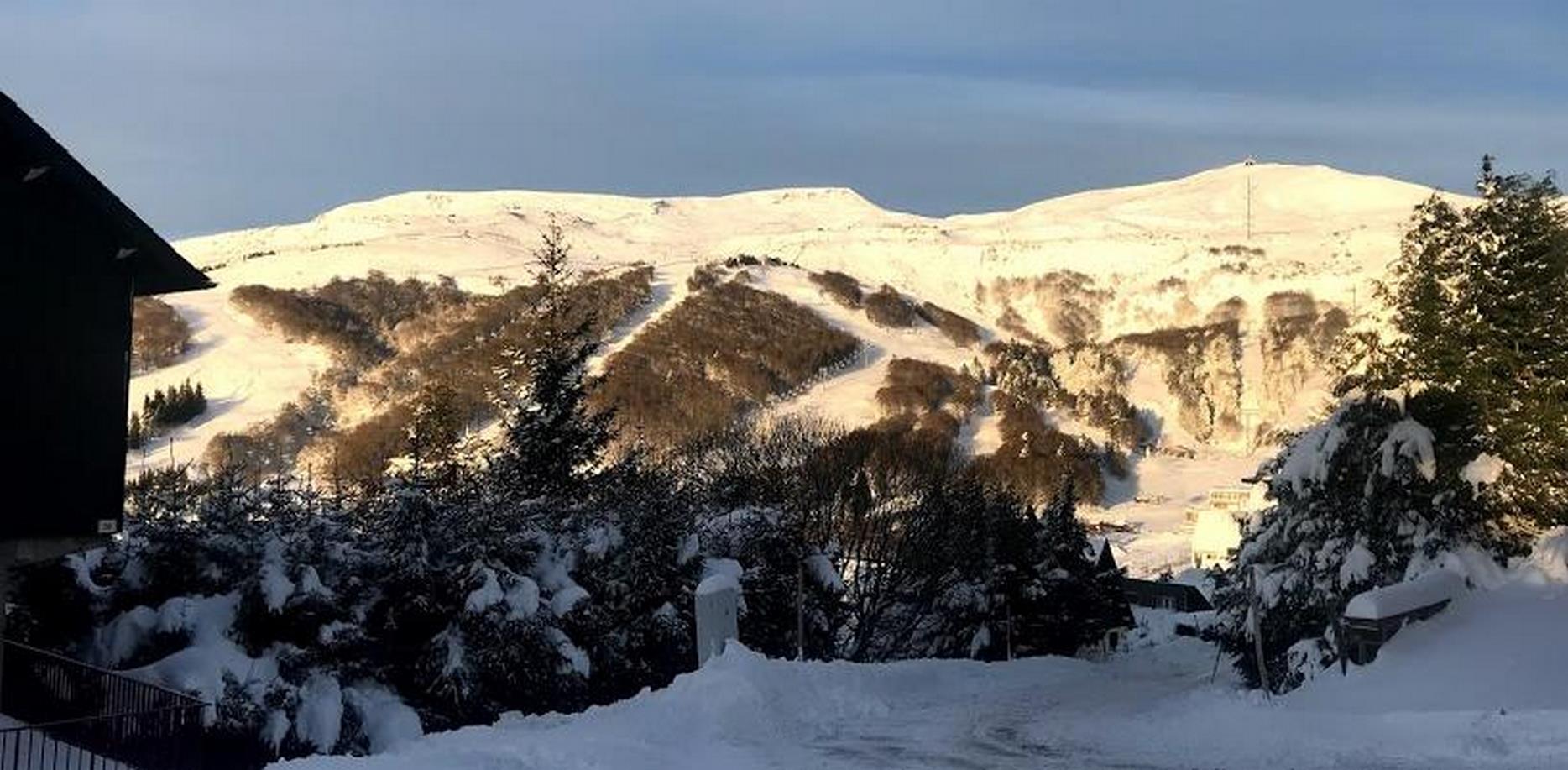 Chalet avec vue sur le téléphérique de la Perdrix sous la neige en hiver