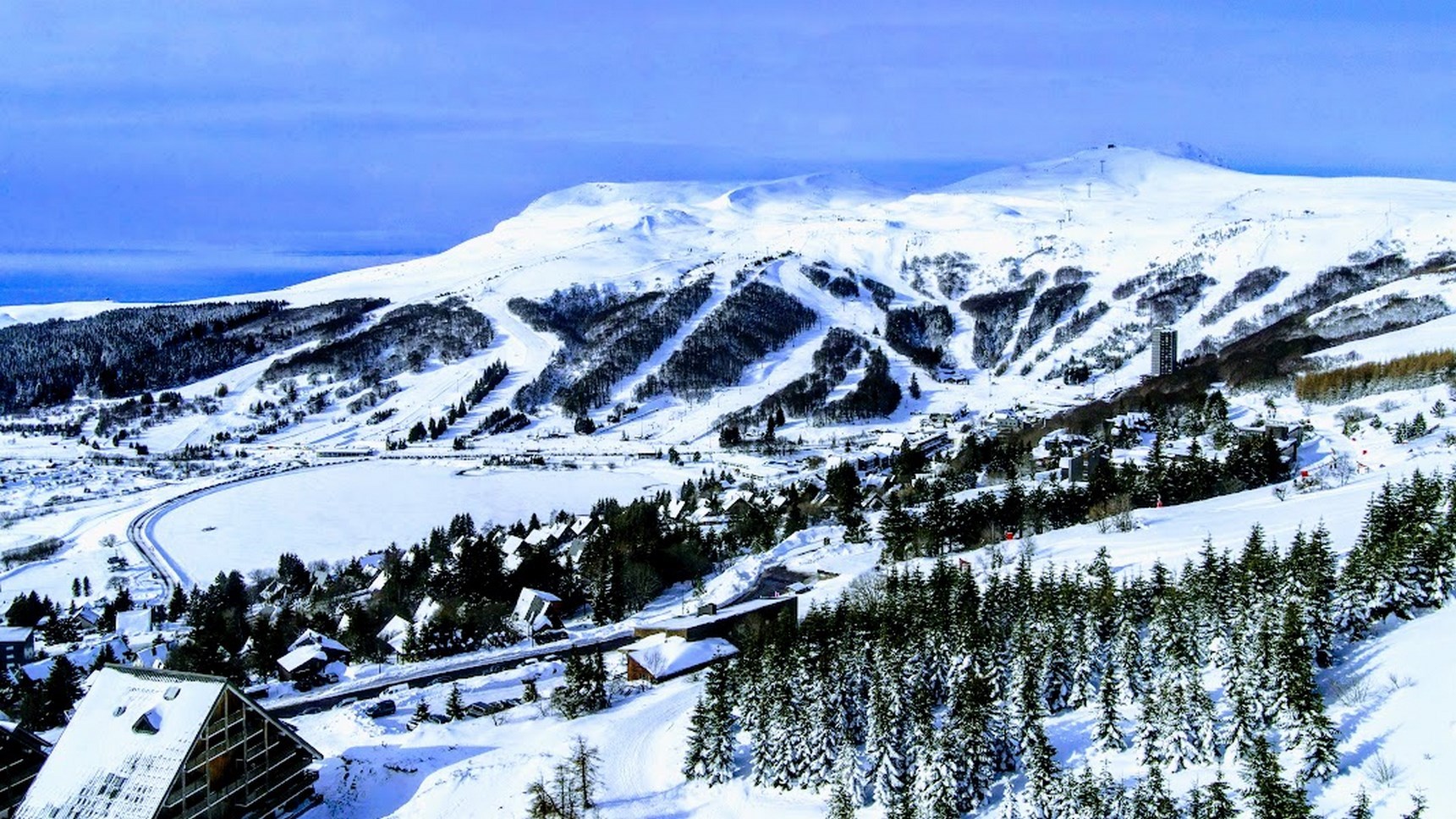 Large panorama de la station de ski de Super Besse vu à l'est depuis le Chalet Ma Cambuse.