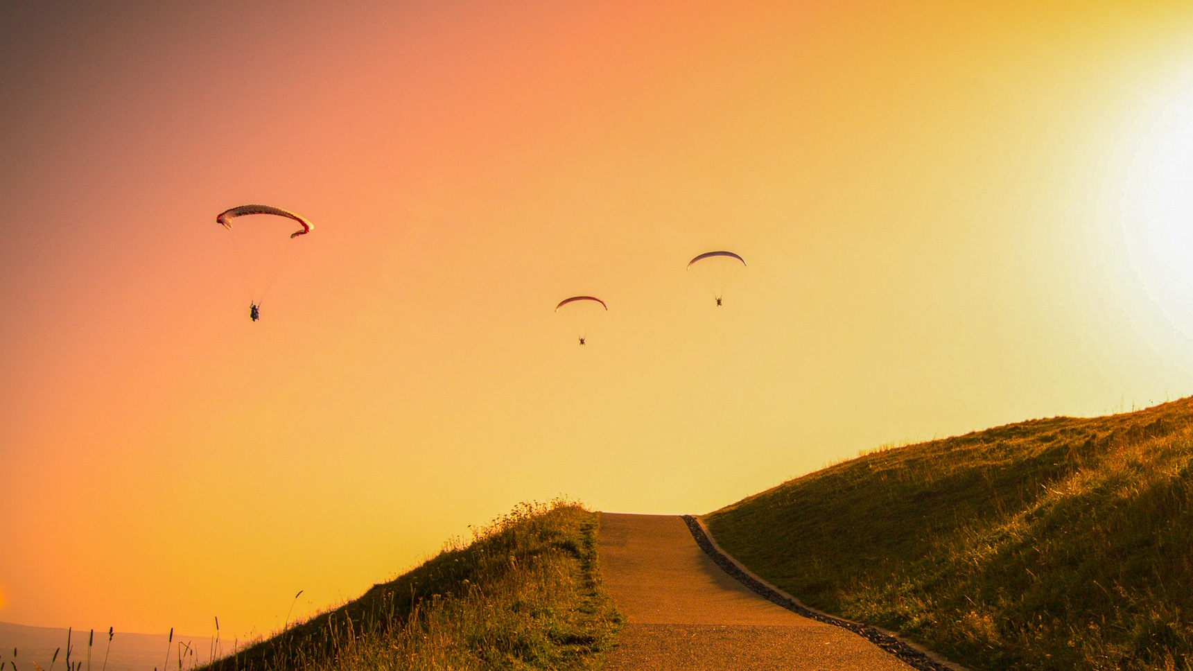 Au Sommet du Puy de Dôme, parapentiste au dessus du Sommet au coucher du Soleil